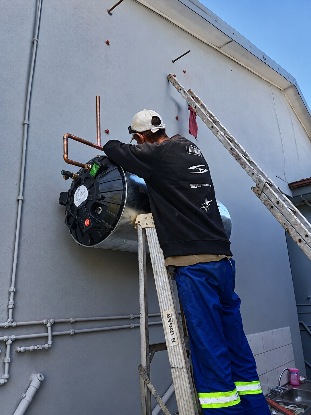Hilton installing an outdoor wall-mounted geyser